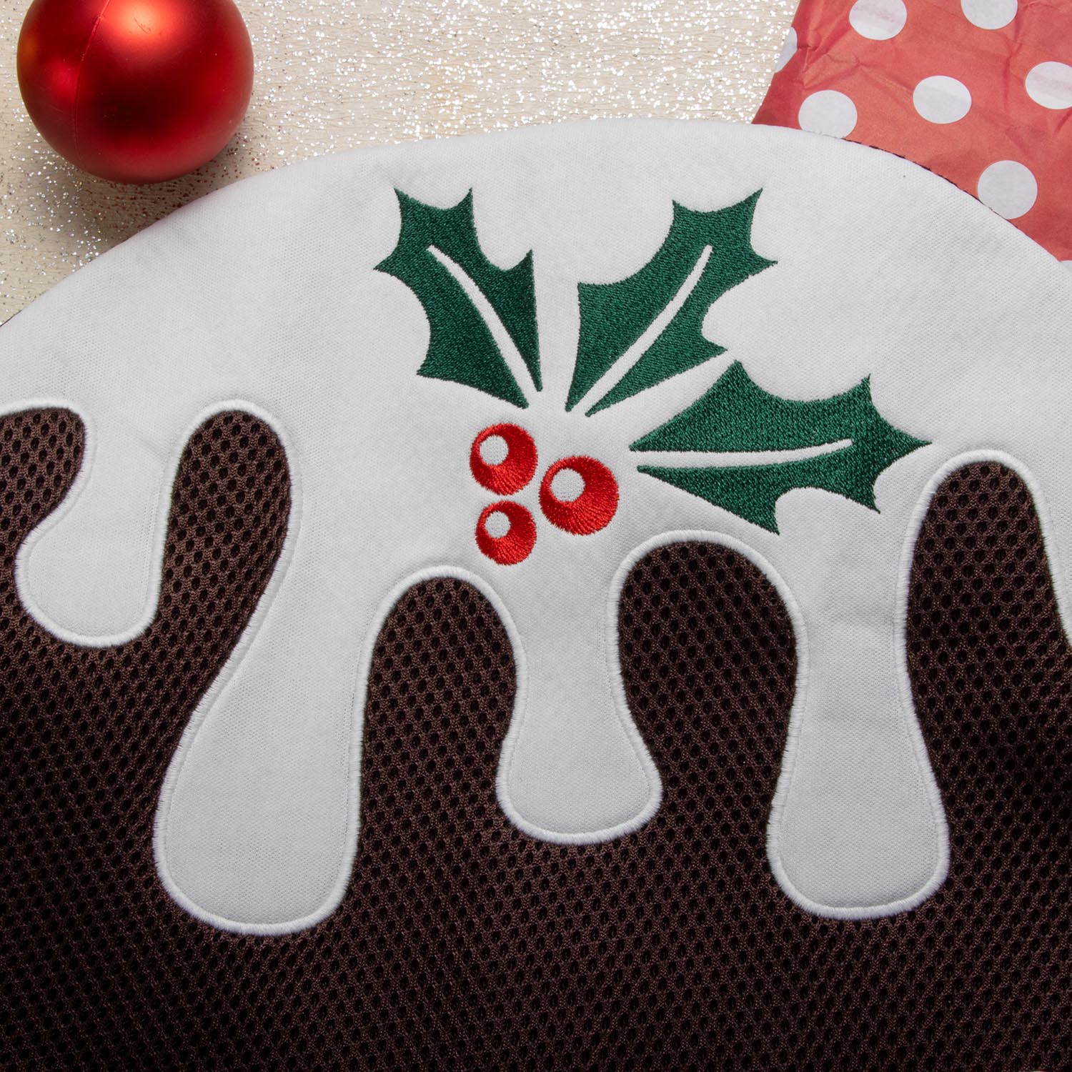 Een close-up detailopname van de puddingwastas, die de textuur van de bruine netstof en de witte 'glazuur'-applicatie laat zien.